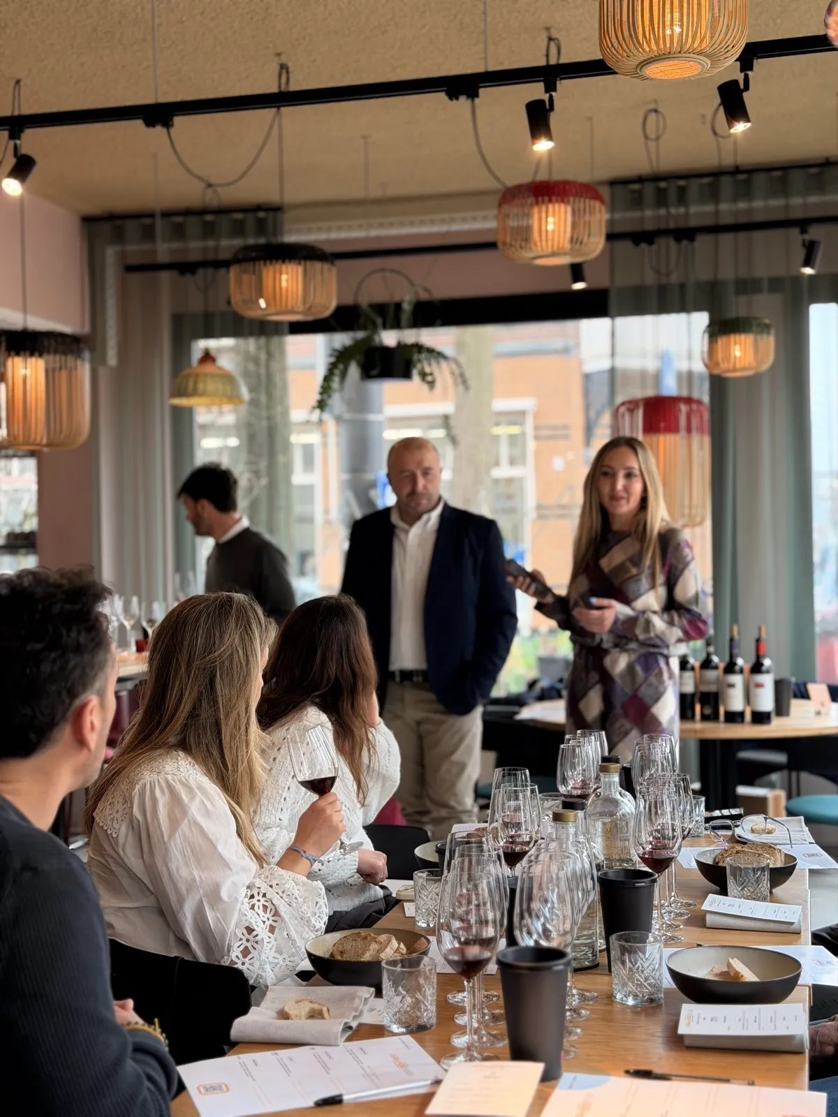 The tasting room of La Grande Bellezza 2026 in Amsterdam, daylight and Amsterdam facades behind the window