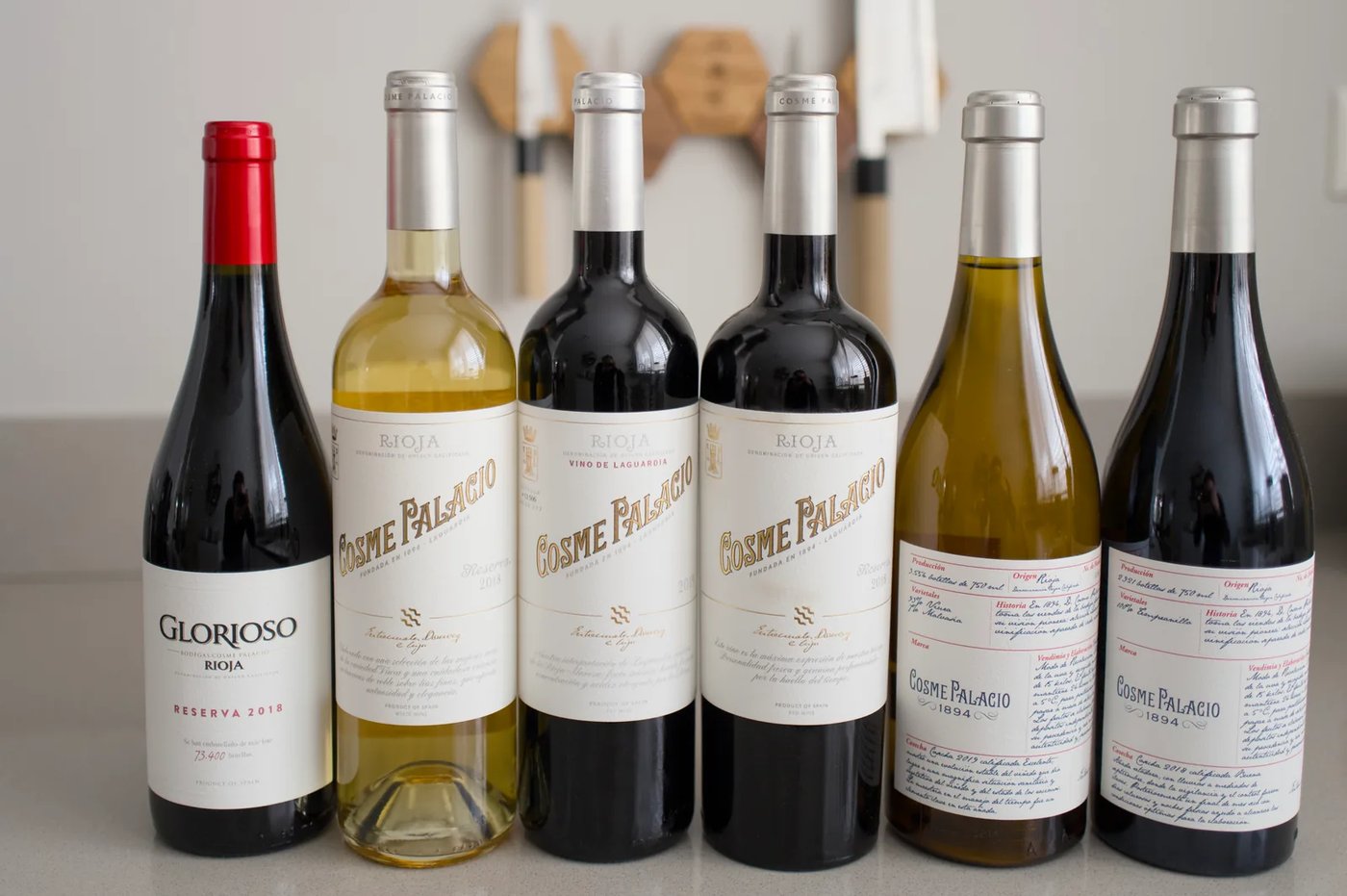 Six bottles from Bodegas Cosme Palacio in a row: Glorioso, Cosme Palacio and the 1894 line