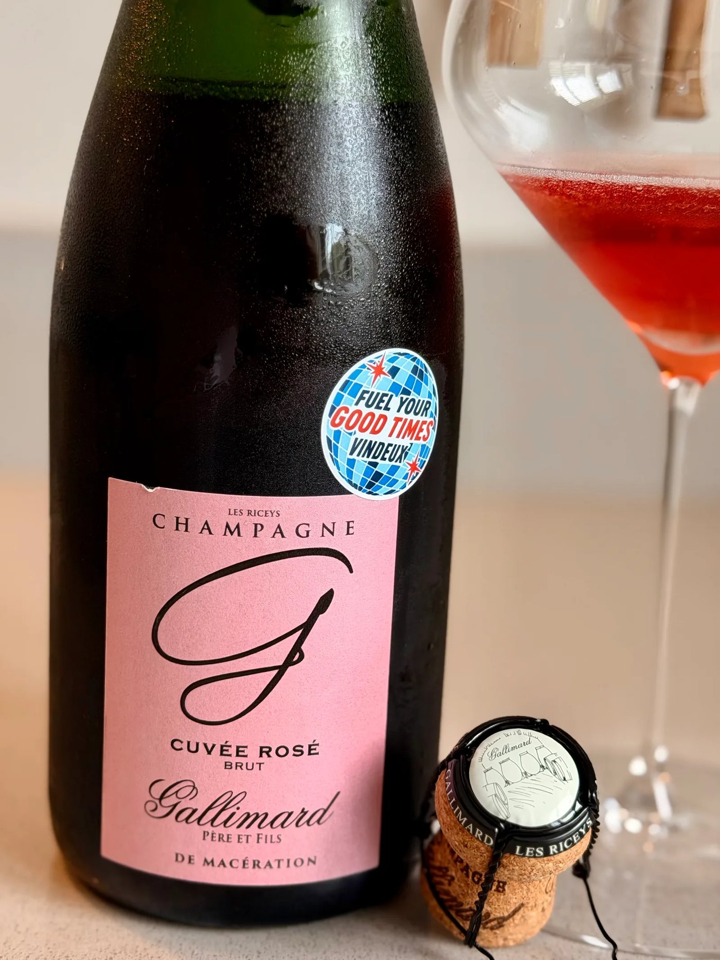 Bottle of Champagne Gallimard Cuvée Rosé from Les Riceys next to a glass of deep red-pink champagne