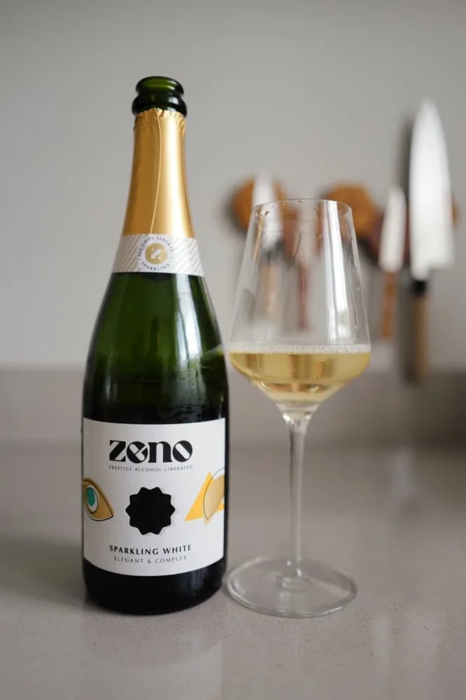 Bottle of Zeno Sparkling White alcohol-free sparkling wine beside a glass