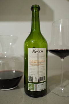 Back of a Vivanco Rioja bottle with a decanter and glass on a light surface