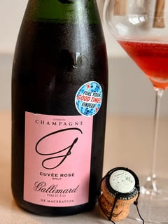 Bottle of Champagne Gallimard Cuvée Rosé from Les Riceys next to a glass of deep red-pink champagne