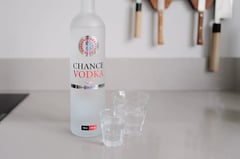 Bottle of Chance Vodka with roulette-wheel label next to two glasses on the counter