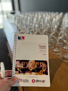 Glasses of French wine on a tasting table at Tastin' France 2024 in Amsterdam.