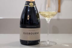 Gusbourne Brut Reserve 2019 bottle next to sparkling wine glass