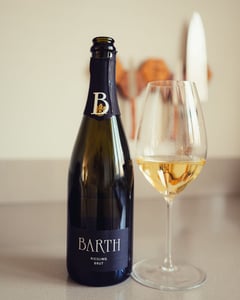 Bottle of Barth Riesling Brut from Rheingau next to a glass of sparkling wine