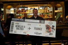 Mathias Schäffer holds up a giant boarding pass reading Benelux & Baltics to France after winning the Giffard West Cup 2026 in Brussels