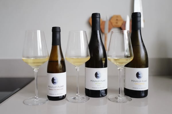 Three bottles of Pouilly-Fumé from Domaine du Bouchot beside three poured glasses