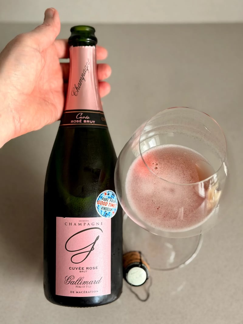 Glass of Gallimard Cuvée Rosé with pink mousse beside the bottle